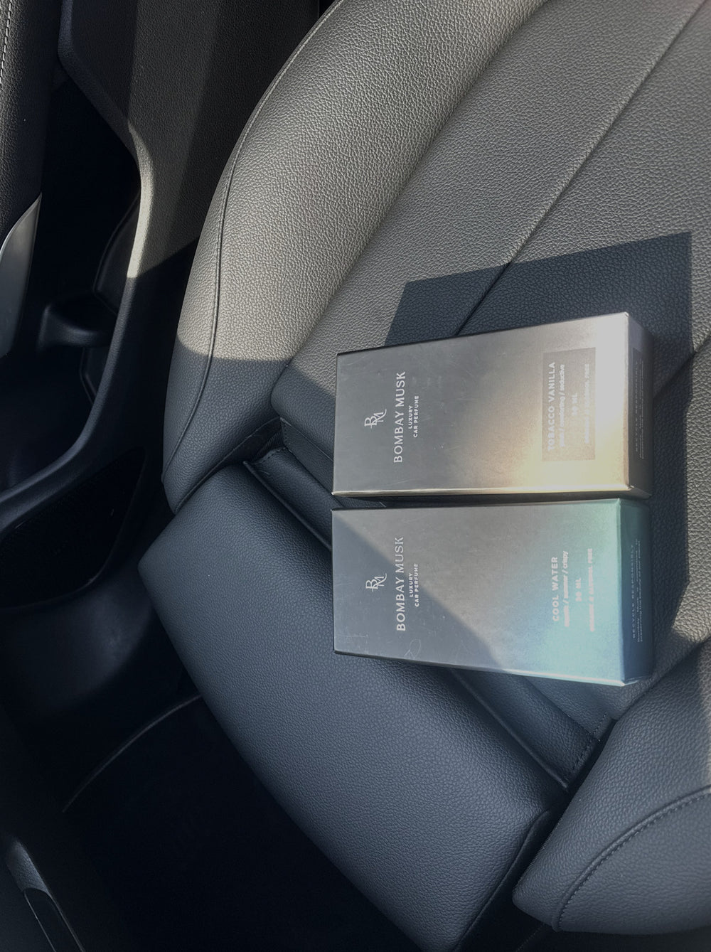 Two Bombay Musk luxury car perfume cartons resting on a car seat